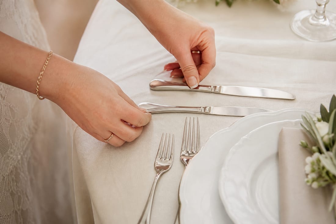 Exemple : mains rangeant des couverts sur une nappe