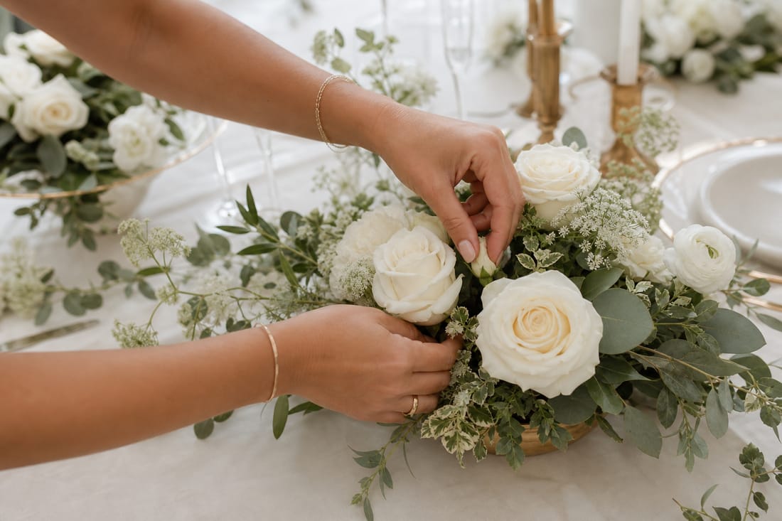 Exemple : mains disposant des fleurs sur un centre de table